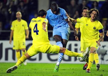 Tiền vệ Yaya Toure (áo xanh, Man.City) tung cú sút trước hàng phòng ngự Villarreal.