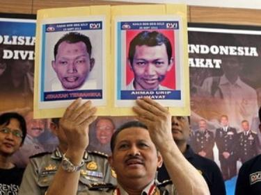 Cảnh sát Indonesia đang giơ hình ảnh hai nghi can khủng bố vừa bắt giữ.