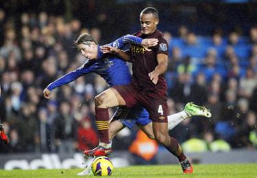 Fernando Torres (trái, Chelsea) cố gắng vượt qua trung vệ Vincent Kompany của Man.City.
