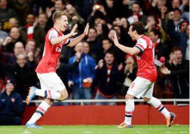 Aaron Ramsey (trái) và Santi Cazorla cùng ghi bàn vào lưới Liverpool giúp Arsenal giữ vững ngôi đầu bảng.