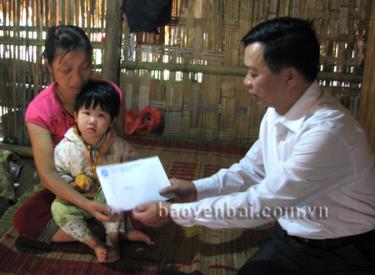Đồng chí Nông Văn Lịnh - Ủy viên Ban Thường vụ Tỉnh ủy, Chủ tịch Ủy ban MTTQ tỉnh trao tiền hỗ trợ làm nhà từ Quỹ “Vì người nghèo” cho gia đình chị Hoàng Thị Hải Yến - thôn 3 Chuông Ính, xã Tân Lĩnh (Lục Yên).