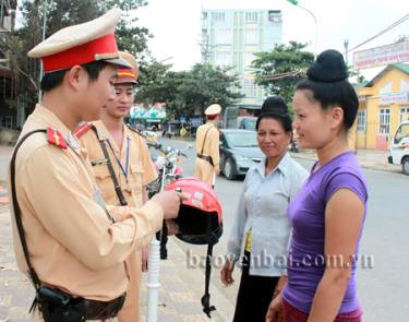 Các chiến sỹ cảnh sát giao thông hướng dẫn người dân nhận biết mũ bảo hiểm đạt chuẩn.