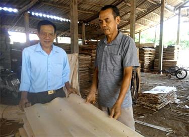 Cựu chiến binh Phạm Minh Hoạt (bên phải) sản xuất, kinh doanh hiệu quả với cơ sở sản xuất gỗ ván bóc.