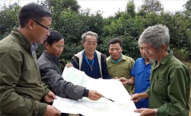 Thôn Làng Mảnh do UBND xã Sùng Đô, huyện Văn Chấn quản lý về hành chính nhưng lại có địa giới ở xã Phong Dụ Thượng, huyện Văn Yên. (Ảnh: Lãnh đạo xã Sùng Đô và nhân dân thôn Làng Mảnh đối chiếu thực địa điểm giáp ranh trên đồi Sùng Sâu trên bản đồ hành chính).