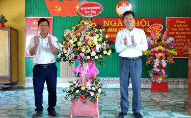 Đồng chí Ngô Hạnh Phúc - Phó Chủ tịch UBND tỉnh (bên phải ) tặng hoa chúc mừng nhân dân thôn Trung Tâm, xã Mông Sơn, huyện Yên Bình.