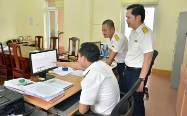 Cán bộ Đội thuế số 4 Chi cục Thuế khu vực Trấn Yên - Văn Yên trao đổi nghiệp vụ thu ngân sách.
