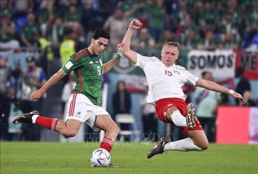 Tiền đạo Mexico Raul Jimenez (trái) tranh bóng với trung vệ Kamil Glik của Ba Lan.