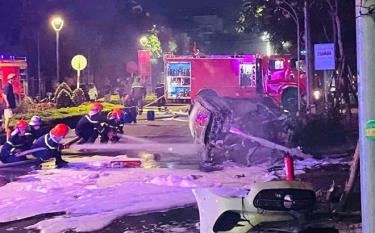 Lực lượng chức năng dập tắt đám cháy khi chiếc xe Mercedes lao vào bùng binh trung tâm thành phố Đồng Hới.