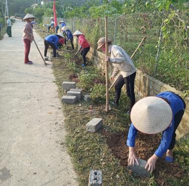 Hội viên phụ nữ xã Hán Đà tham gia xây dựng các tuyến đường hoa.