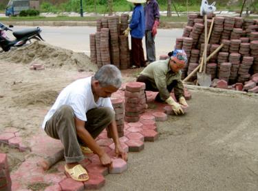 Công nhân xây dựnng thi công hành lang đường Nguyễn Tất Thành, thành phố Yên Bái.