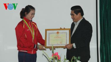 Ông Doãn Văn Hưởng - Chủ tịch UBND tỉnh Lào Cai trao phần thưởng cho vận động viên Lừu Thị Duyên.
