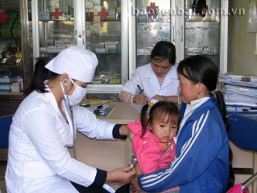 Cán bộ y tế xã Bản Công khám bệnh cho trẻ em.