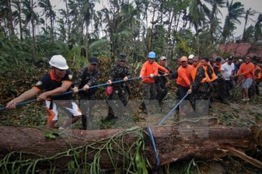 Binh sỹ Philippines dọn cây đổ trên một tuyến đường cao tốc ở thị trấn Taft, Đông samar, miền trung Philippines ngày 8/12.