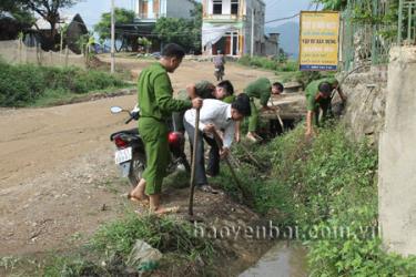 Các cán bộ, chiến sỹ trong đoàn công tác Công an tỉnh giúp dân xã Lâm Giang khơi thông cống rãnh, phát quang lề đường.
