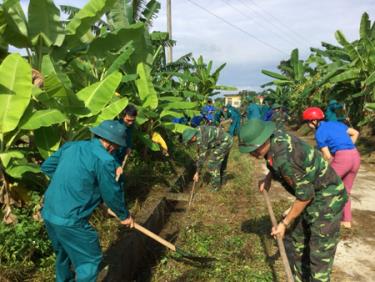 Cán bộ, chiến sỹ Ban Chỉ huy Quân sự huyện Trấn Yên phối hợp với dân quân và thanh niên xã Đào Thịnh nạo vét kênh mương.
