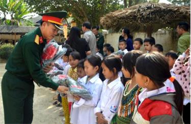 Đại tá Lê Văn Trung - Chỉ huy trưởng Bộ Chỉ huy Quân sự tỉnh tặng quà cho học sinh bị ảnh hưởng thiên tai tại xã An Lương, huyện Văn Chấn.