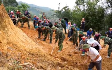 Cán bộ, chiến sĩ Bộ Chỉ huy quân sự tỉnh và Ban Chỉ huy quân sự huyện Mù Cang Chải giúp người dân xã Chế Cu Nha làm đường giao thông nông thôn.