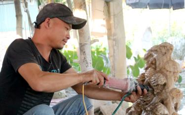 Hoang Xuan Khuc works on a stone statute.