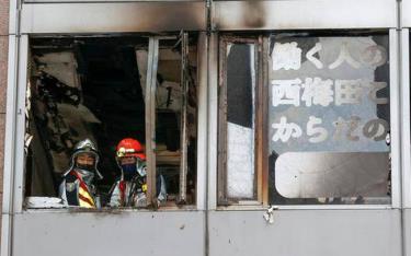 Lính cứu hỏa tại cửa sổ tầng lầu bùng phát đám cháy trong một tòa nhà ở thành phố Osaka, Nhật Bản ngày 17/12