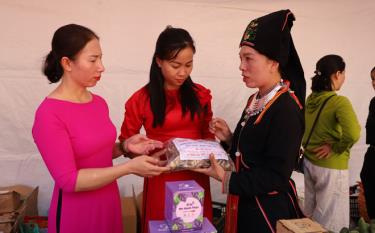Mrs. Mai Thi Thong (R) introduces herbal medicine products of the Dao people to consumers.
