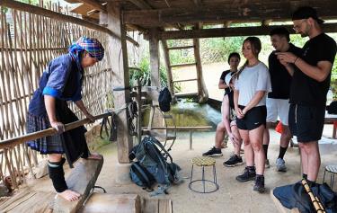 Foreign tourists visit the use of stone irons for ironing fabric by the H'Mong people in Mu Cang Chai district.