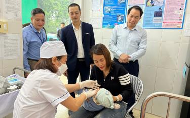 ThS.BSCKII Nguyễn Trung Hiếu - Phó Giám đốc Sở Y tế (mặc áo đen) và bác sĩ chuyên khoa II Lại Mạnh Hùng - Giám đốc Trung tâm Kiểm soát bệnh tật tỉnh Yên Bái (người ngoài cùng, bên phải) kiểm tra, giám sát công tác uống vắc xin trong ngày đầu triển khai.