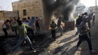 Thanh niên Palestine ném đá vào các binh sĩ Israel.
