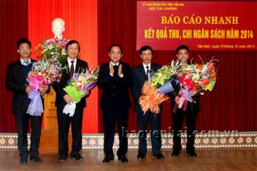 Đồng chí Tạ Văn Long (người đứng giữa) - Phó chủ tịch Thường trực UBND tỉnh tặng hoa cho các đơn vị hoàn thành tốt nhiệm vụ thu ngân sách Nhà nước năm 2014.
