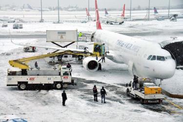 Công nhân hối hả dọn tuyết quanh máy bay của hãng Turkish Airlines đang đậu tại phi trường ở thành phố Istanbul.