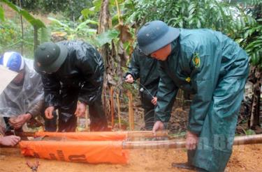 Lực lượng công binh gói buộc lượng nổ vào bom và chèn cát hủy nổ.