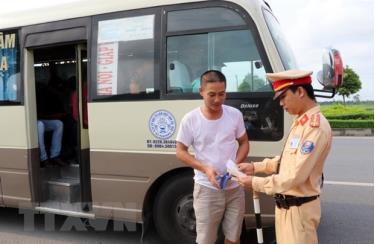 Cảnh sát giao thông kiểm tra phương tiện vận chuyển khách tại chốt giao thông.