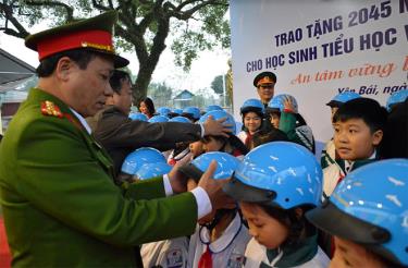 Lãnh đạo Ban An toàn giao thông tỉnh hướng dẫn học sinh đội mũ bảo hiểm.