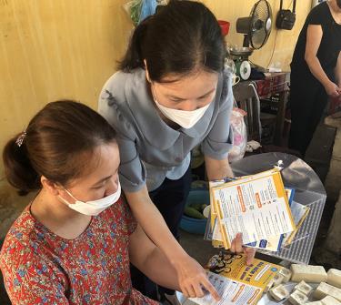 Chị Nguyễn Thị Mai - cộng tác viên thu bảo hiểm xã hội, bảo hiểm y tế phường Nguyễn Phúc, thành phố Yên Bái tuyên truyền, vận động các tiểu thương ở chợ Nguyễn Phúc tham gia bảo hiểm xã hội tự nguyện.
