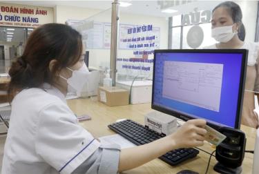 Nhân viên y tế dùng máy quét QR code trên Căn cước công dân gắn chíp để tra cứu thông tin người bệnh tại Trung tâm y tế huyện Tân Yên, Bắc Giang.