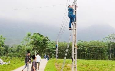 Người dân xã Tân Lập, huyện Lục Yên tham gia xây dựng công trình “Thắp sáng đường quê”.