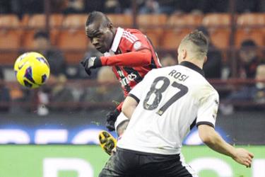 Tiền đạo Mario Balotelli (trái, AC Milan) tung cú dứt điểm trước hậu vệ Parma Aleandro Rosi.
