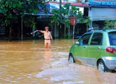 Cảnh sát Giao thông thành phố Yên Bái phân luồng giao thông tại thôn Nước Mát, xã Âu Lâu trong mùa mưa lũ.
(Ảnh: Yhanh Miền)