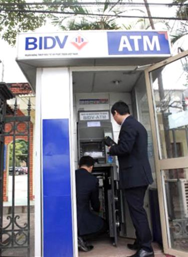 Cán bộ BIDV Yên Bái kiểm tra hệ thống cây ATM bảo đảm hoạt động thông suốt.