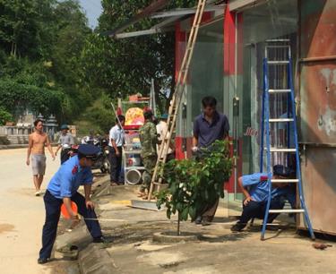 Lực lượng thanh tra giao thông phối hợp với huyện Yên Bình thực hiện đo chỉ giới hành lang đường bộ trên quốc lộ 37.