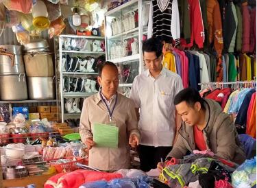 Cán bộ Chi cục Thuế khu vực Nghĩa Văn - Trạm Tấu hướng dẫn hộ kinh doanh ở chợ Mường Lò kê khai lệ phí môn bài năm 2021.