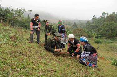 Cán bộ Hạt Kiểm Lâm huyện Văn Chấn tuyên truyền, hướng dẫn người dân chăm sóc, quản lý hiệu quả diện tích rừng được giao khoán bảo vệ.