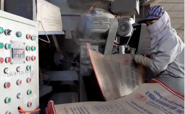 Workers at Yen Bai Cement Company, a member of Yen Bai Cement and Minerals JSC, work in the packaging line.