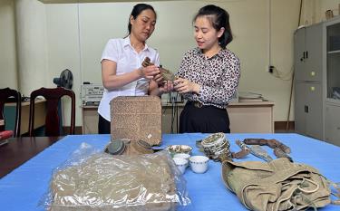 Phóng viên Thu Trang Báo Yên Bái (bên phải) cùng cán bộ Bảo tàng tỉnh tìm hiểu những hiện vật lịch sử của cuộc chiến đấu bảo vệ biên giới phía Bắc.