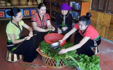 An elderly woman in Nghia An commune of Nghia Lo township teaches her descendants how to cook traditional dishes.