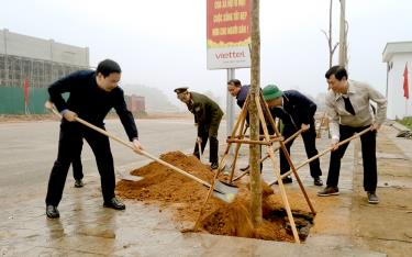 Đồng chí Nguyễn Minh Tuấn - Ủy viên Ban Thường vụ, Trưởng Ban Tuyên giáo Tỉnh ủy cùng lãnh đạo huyện Yên Bình trồng cây tại khu vực Nhà thi đấu huyện Yên Bình.