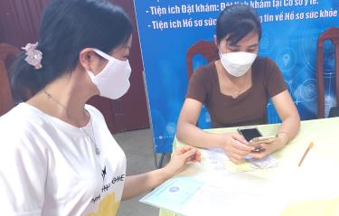 A staff member at the Mau A Town Health Station in Van Yen District assists residents in utilizing digital services.