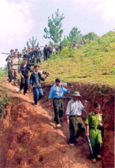 Đồng bào Mông xã Chế Tạo, huyện Mù Cang Chải trên đường vận chuyển súng săn tự chế về giao nộp tại Công an huyện.