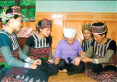 Cụ Bơ Thị Ma đang truyền dạy con, cháu thêu hoa văn trên váy, áo truyền thống của dafabet dang nhap Xa Phó.  
