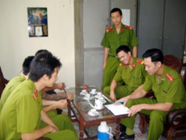 Anh Nguyễn Văn Hoan (người cầm bút) đang trao đổi công việc với các chiến sĩ trong đội cảnh sát bảo vệ.