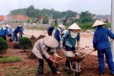 Nữ công nhân lao động Công ty Công trình và Môi trường đô thị chỉnh trang đường phố. (Ảnh: T.H)